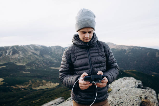 istock The man using a remote controller to operate the drone in the mountains 1437221180