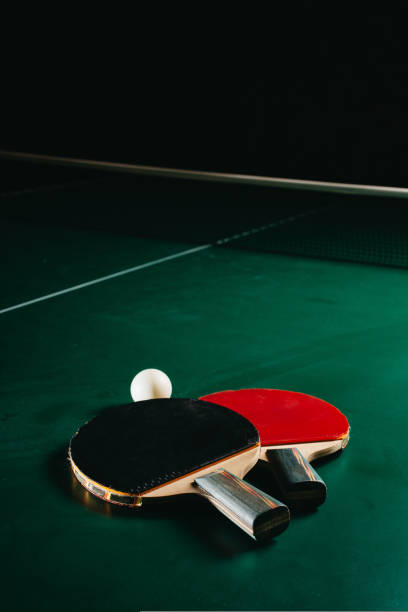 istock Two ping pong rackets and a ball are on the green game table 1437221245