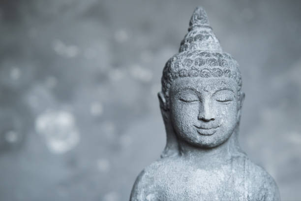istock Statue Buddha with closed eyes on grey stone background close up with copy space. meditation and spirituality background 1437221745