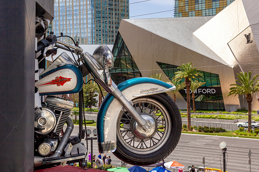 Las Vegas, USA - 24 April 2012: Harley Davidson motor bike coming out of the wall at the Harley Davidson Cafe on the Las Vegas Strip with luxury stores beyond.