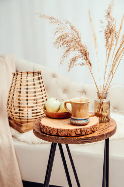 Cozycore or cottagecore concept, warm soft brown beige interior design objects. Cozy wool plaid on sofa, candle burning in wood lantern, tea cup on wood table. Warm color photo manipulation. concepto cozycore o cottagecore, cálidos objetos de diseño de interiores de color beige marrón suave. acogedora lana a cuadros en el sofá, vela encendida en linterna de madera, taza de té en mesa de madera. manipulación de fotos en color cálido.