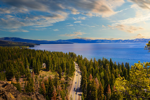 Sunset view from the Eagle Rock at Lake Tahoe and nearby road, California, with Sierra Nevada Mountains in the background.