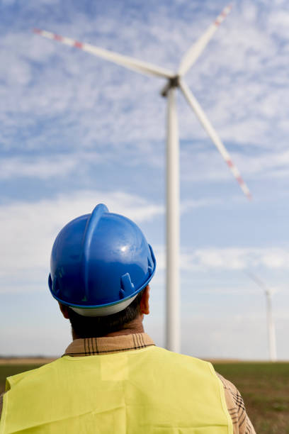 Rear view of engineer looking at wind turbine