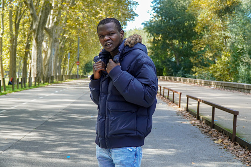 Black people portrait in a park with a coat in the park in winter. authentic and real people