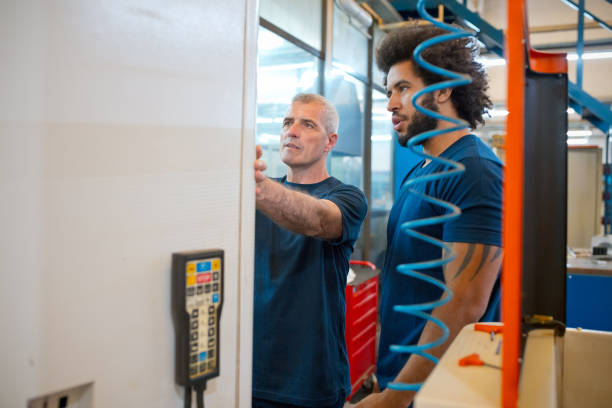 istock Male engineers discussing with each other while working together in factory 1437233895