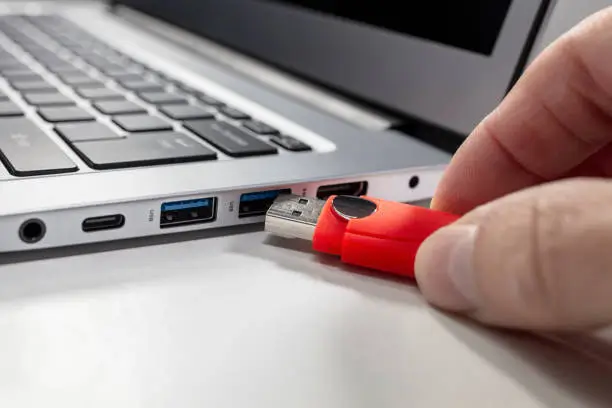 USB flash drive stick being inserting and connected to laptop computer