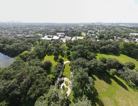 The aerial view of the trees and green fields before the New Orleans cityscape