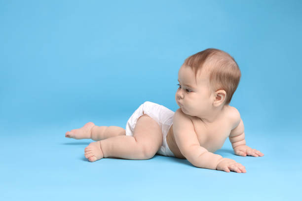 istock Cute little baby in diaper on light blue background. Space for text 1437239205