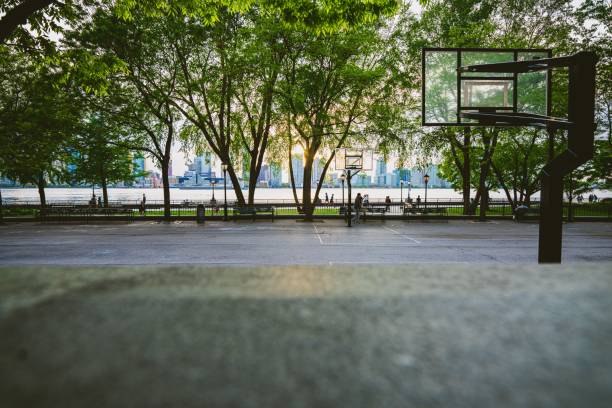 istock Basketball field against trees, benches and a city 1437240418