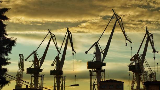 istock Building construction cranes silhouettes with sunset sky background 1437240823