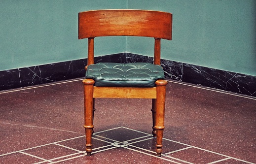 The close-up of single old vintage style chair in the room