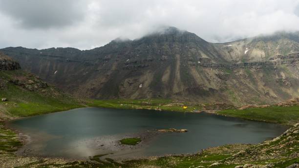 istock Calm lake and mountain landscape under a cloudy sky 1437242723
