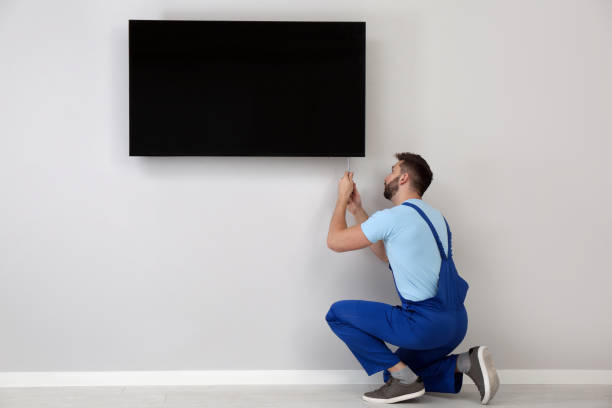 istock Professional technician with screwdriver installing modern flat screen TV on wall indoors 1437247084