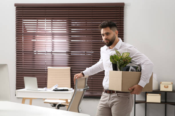 istock Upset dismissed man carrying box with personal stuff in office 1437247088