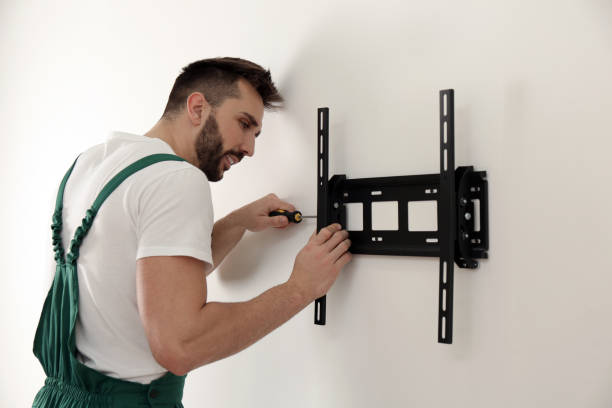 istock Professional technician with screwdriver installing TV bracket on wall indoors 1437247952