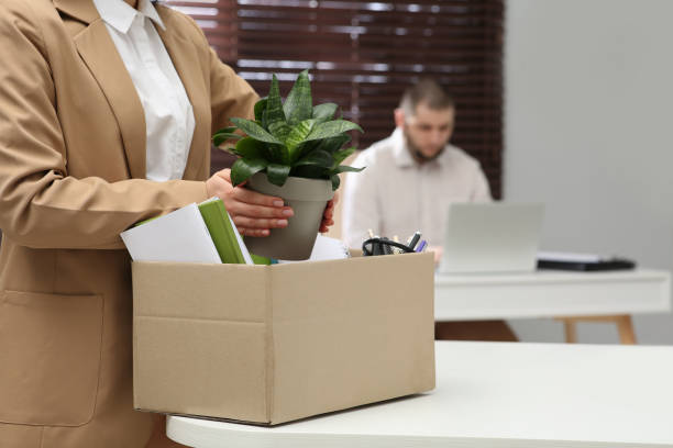 istock Dismissed woman packing personal stuff into box in office, closeup 1437248448