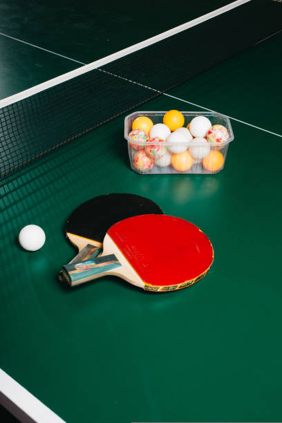 istock Two ping pong rackets and a ball are on the green game table 1437250146