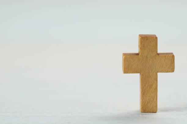 istock Wooden Christian cross on white table, space for text 1437250197