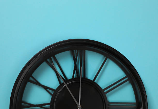 Stylish analog clock hanging on light blue wall, space for text. New Year countdown