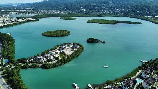 An aerial of hotels on a beach covered with greenery against a turquoise sea in Montego Bay, Jamaica