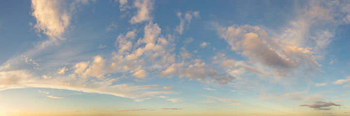 An evening sky with clouds in warm sunlight.