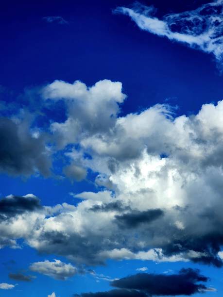 istock Vertical shot of white fluffy clouds in a blue sky 1437252726