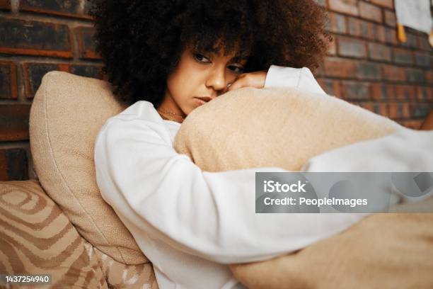 Sad Depressed And Lonely Black Woman With Mental Health Problems Hugging A Pillow At Home Portrait Of A African Afro Female In Depression Stress And Anxiety Feeling Unhappy Living Alone In A House Stock Photo - Download Image Now