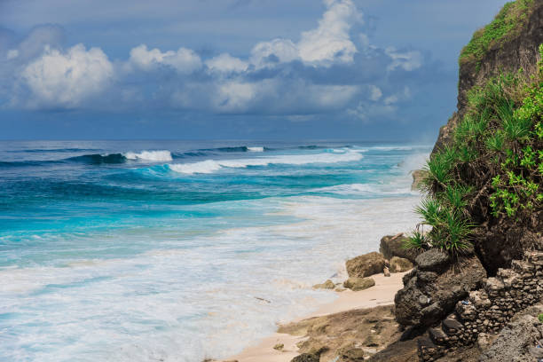 istock Tropical beach with big blue ocean waves in Bali island 1437257900
