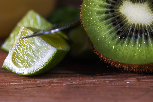 Kiwi detail on wooden table with file and knife.