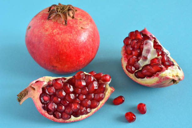 istock group of pomegranate fruit isolated on blue background, close-up 1437264781