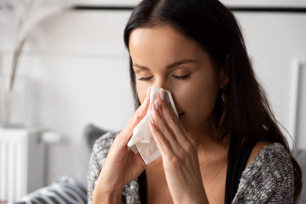 istock Sick woman blowing her nose 1437265304