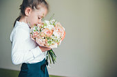Little toddler girl holding in hands beautiful bouquet.
