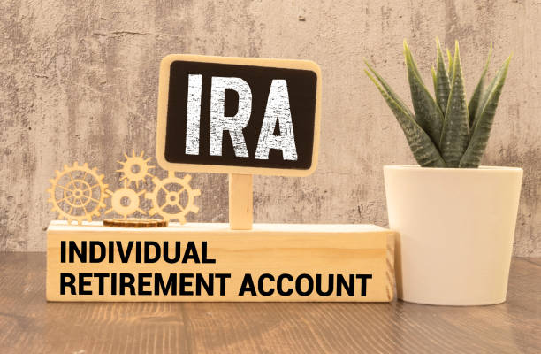 On a bright blue background, light wooden blocks and cubes with the text IRA Individual Retirement Account stock photo