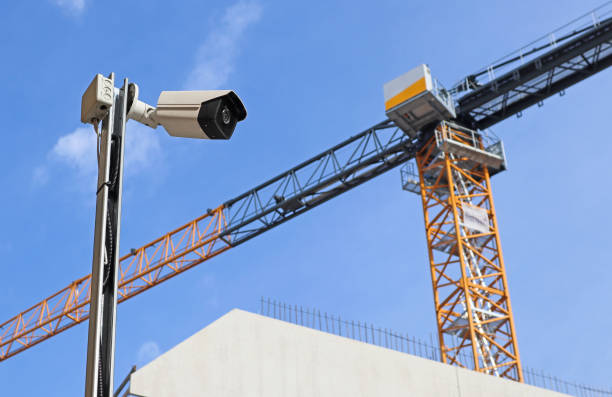 überwachungskamera auf der baustelle mit einem turmdrehkran - security equipment stock-fotos und bilder