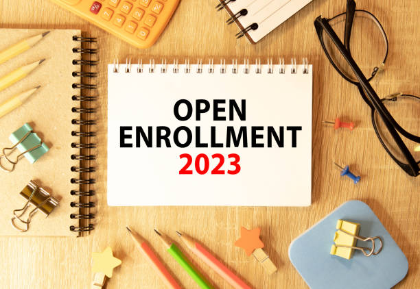 Open Enrollment. Text and a man's hand holding a black marker on a white background. stock photo