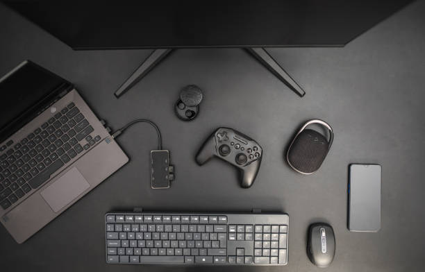 istock Gaming top view desk on dark background with joystick, computer, keyboard, mouse, smarpthone and speaker. Gaming as a job concept 1437274125