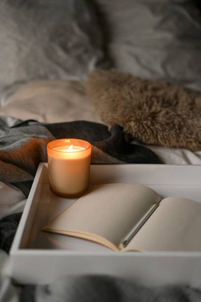 istock wooden tray on bed with burning aromatic candle and notebook 1437275274