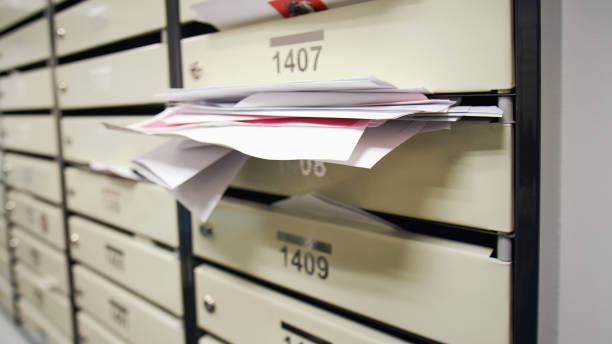 istock Mailboxes filled with letters and bills in an apartment building. An overflowing postbox in the hallway of the house 1437275301