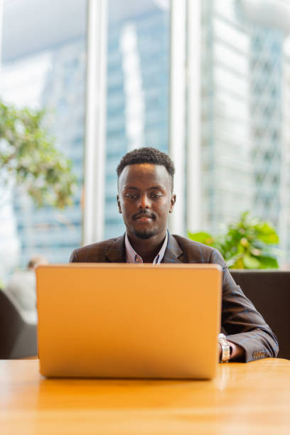 istock Black businessman using laptop computer at coffee shop 1437276199