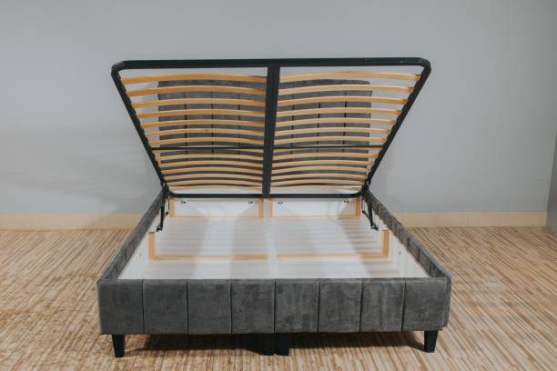 Gray bed with a storage space revealed by lifting the wooden slatted base
