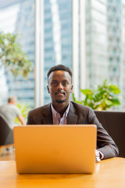 istock Black businessman using laptop computer at coffee shop 1437276392