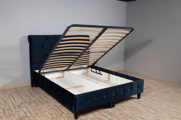 istock Dark blue bed with a storage space revealed by lifting the wooden slatted base 1437276656