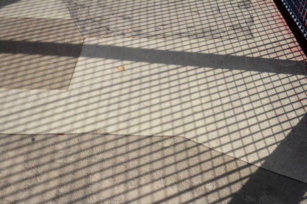 Purple floor covering made of recycled materials. Special rubber coating for children's playground or sports with long shadows of the fence. Protective floor covering with rubber granules.