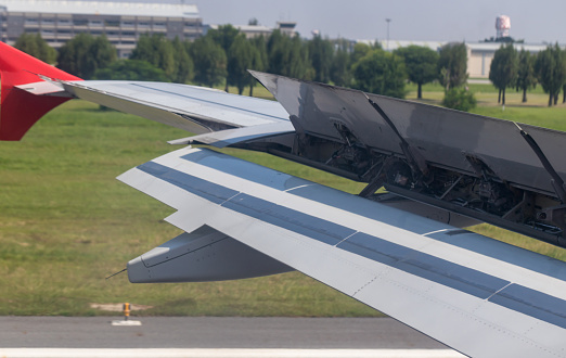Wing braking of the aircraft on the runway. The wing of an aircraft  open flaps on the wing for is landing.