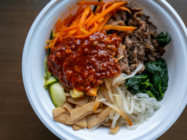 Korean Bibimbap, rice bowl with beef, vegetables, and hot pepper jelly sauce stock photo