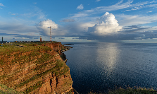 Cliff of Island Helgoland in sunlight with mighty white clouds
