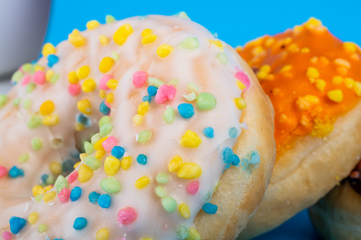Sweet tasty doughnut with sprinkles on blue background