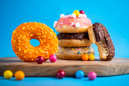 Sweet tasty doughnut with sprinkles on blue background