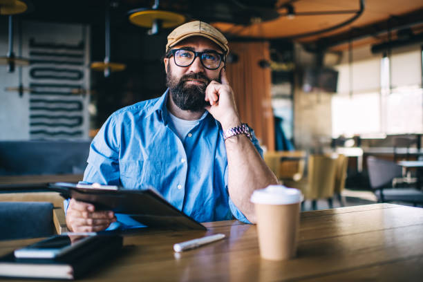 istock Pensive middle aged bearded man with notebook thinking in cafe 1437287620