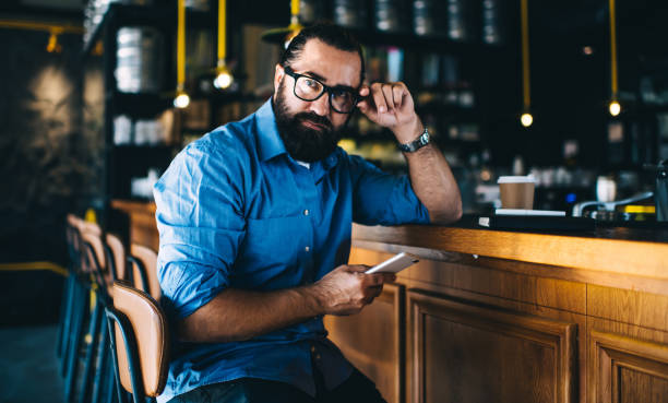 istock Serious senior hipster male using smartphone in cafe 1437287694